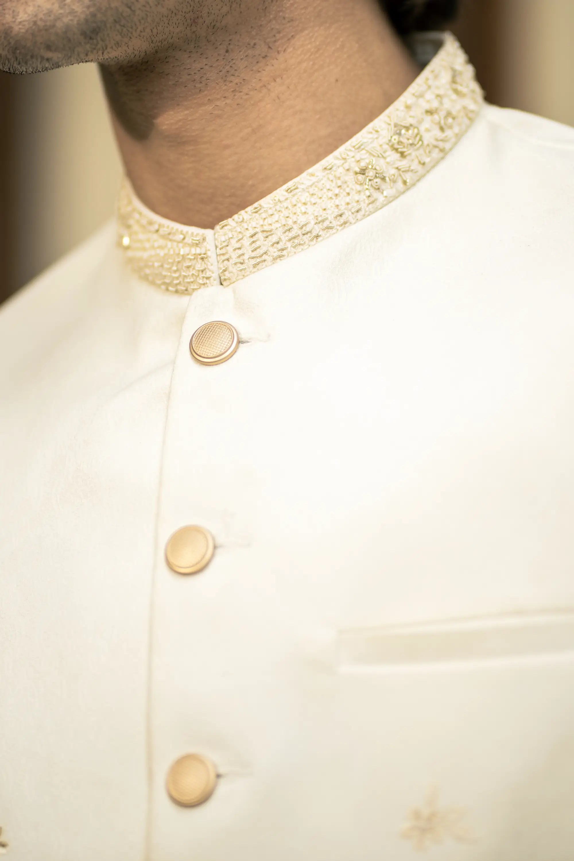 Close-up of a cream-colored shirt with a textured collar and buttons.