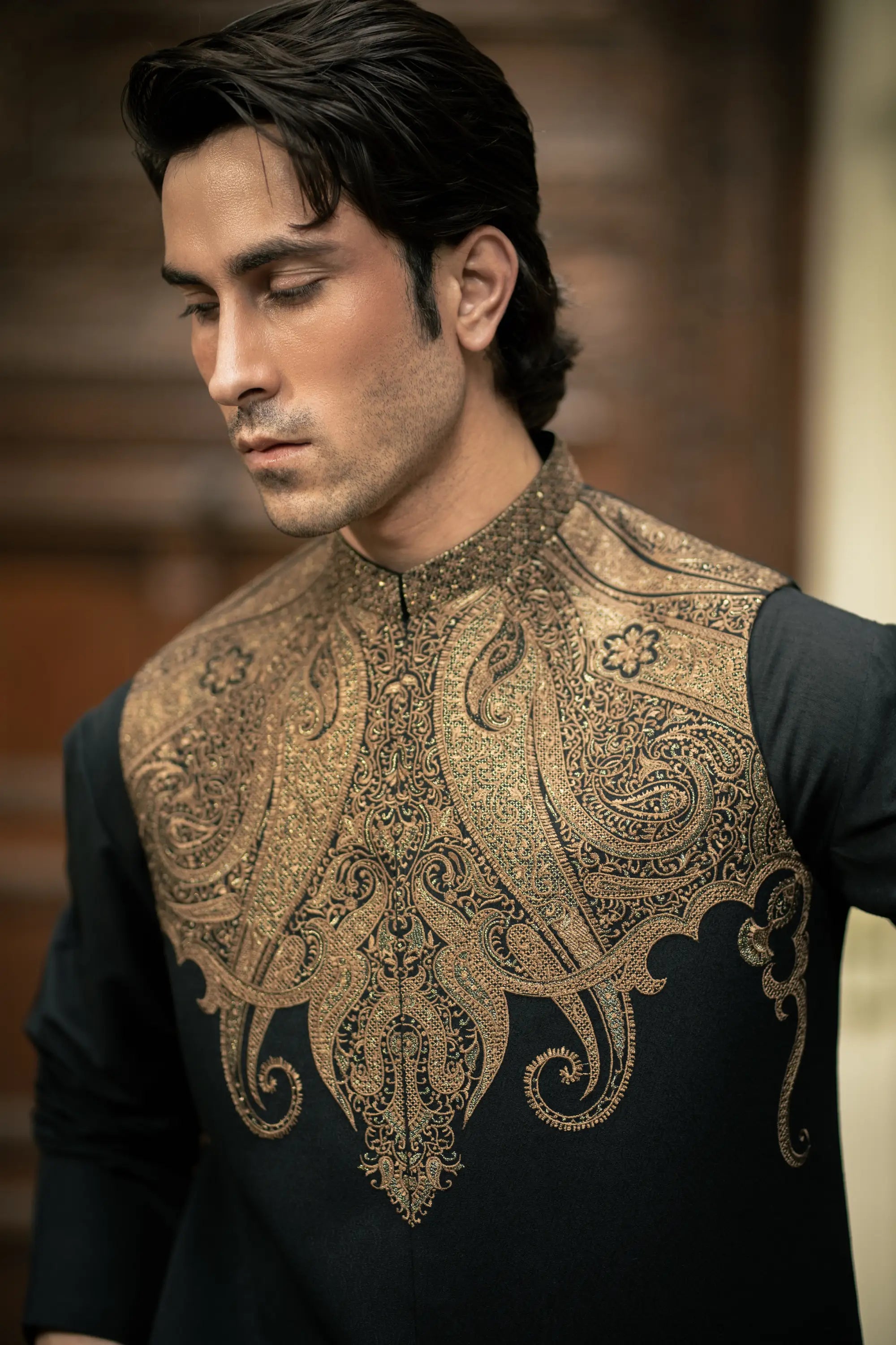 Man wearing a black shirt with intricate gold embroidery