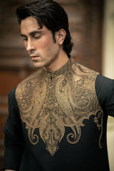 Man wearing a black shirt with intricate gold embroidery