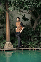 Man standing by a pool with lush greenery in the background
