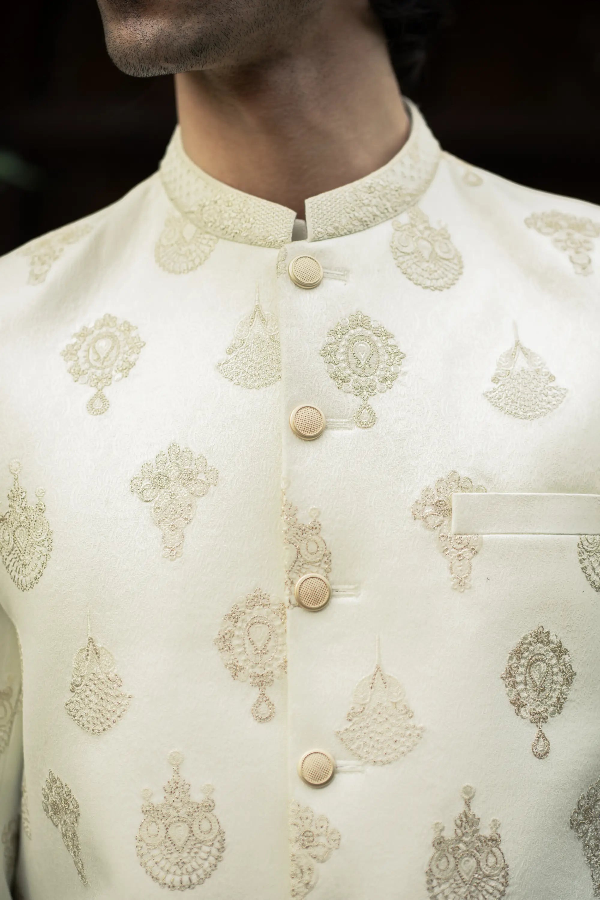 Close-up of a cream-colored embroidered traditional jacket with intricate patterns.