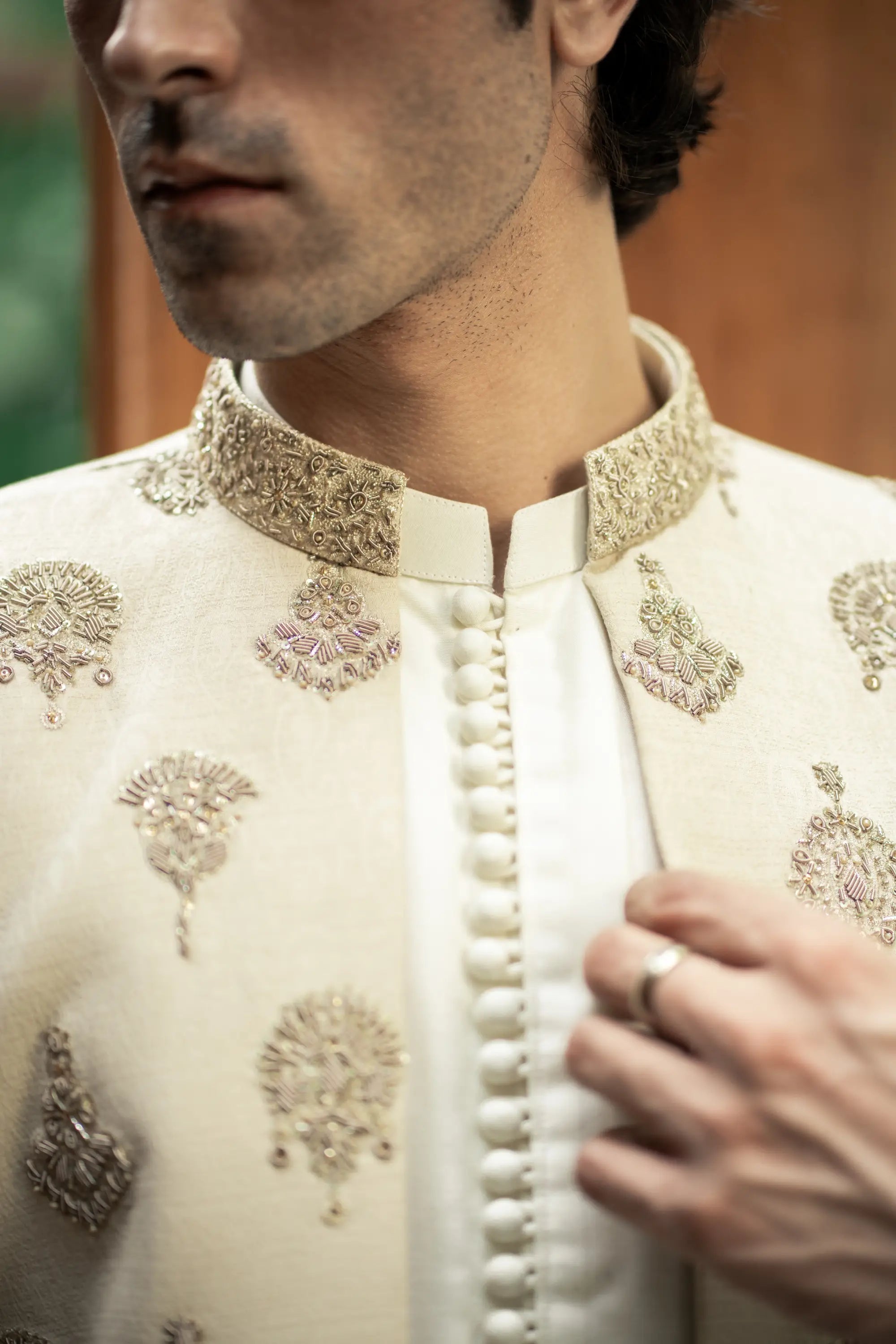 Close-up of a person wearing an embroidered traditional outfit with intricate designs.