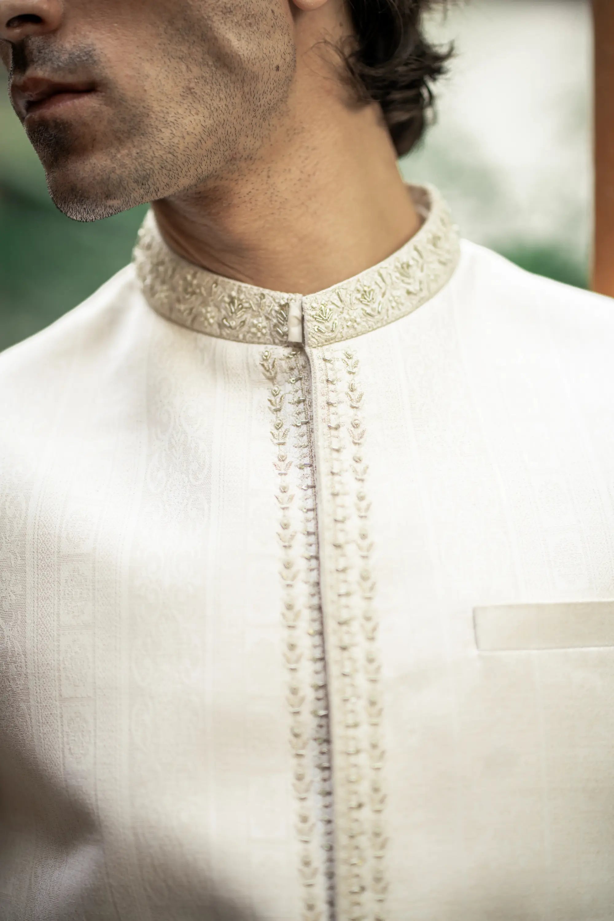 Close-up of a white kurta with intricate embroidery on the collar and chest.