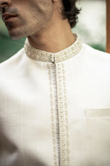 Close-up of a white kurta with intricate embroidery on the collar and chest.