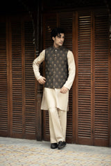 Man wearing a traditional outfit with a vest and kurta against a wooden background
