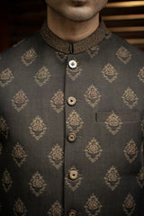 Dark gray traditional jacket with intricate patterns and buttons on a blurred background
