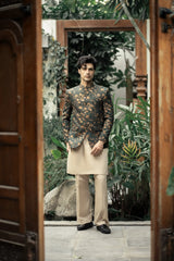 Man in a floral jacket and beige pants standing in a garden setting